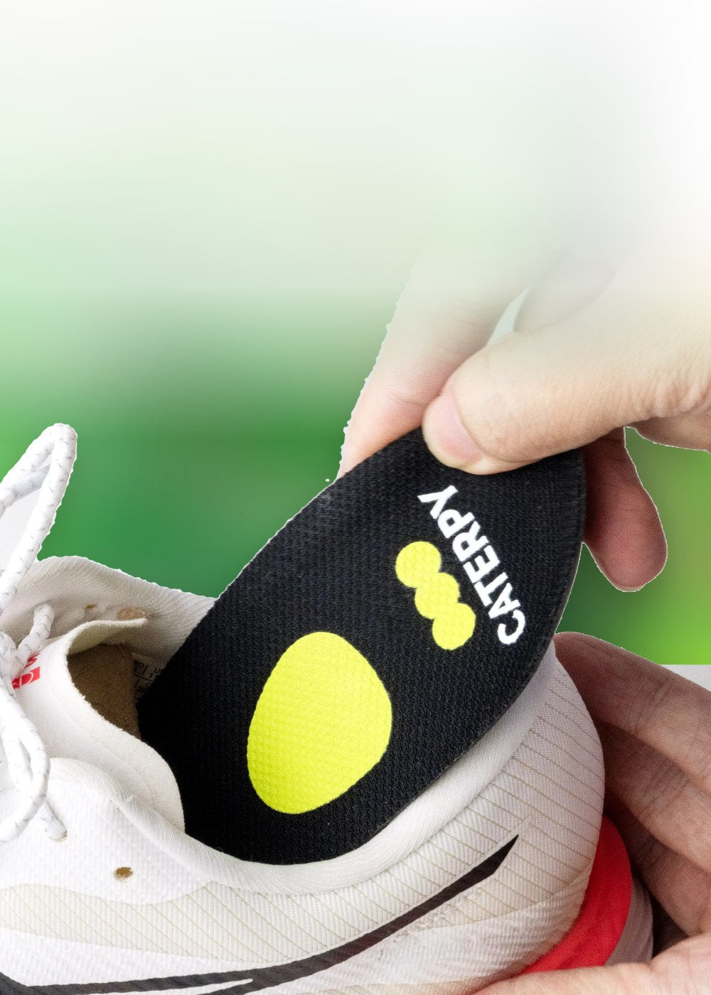 Hand sliding a Caterpy Cuboid Support Insole into a sneaker
